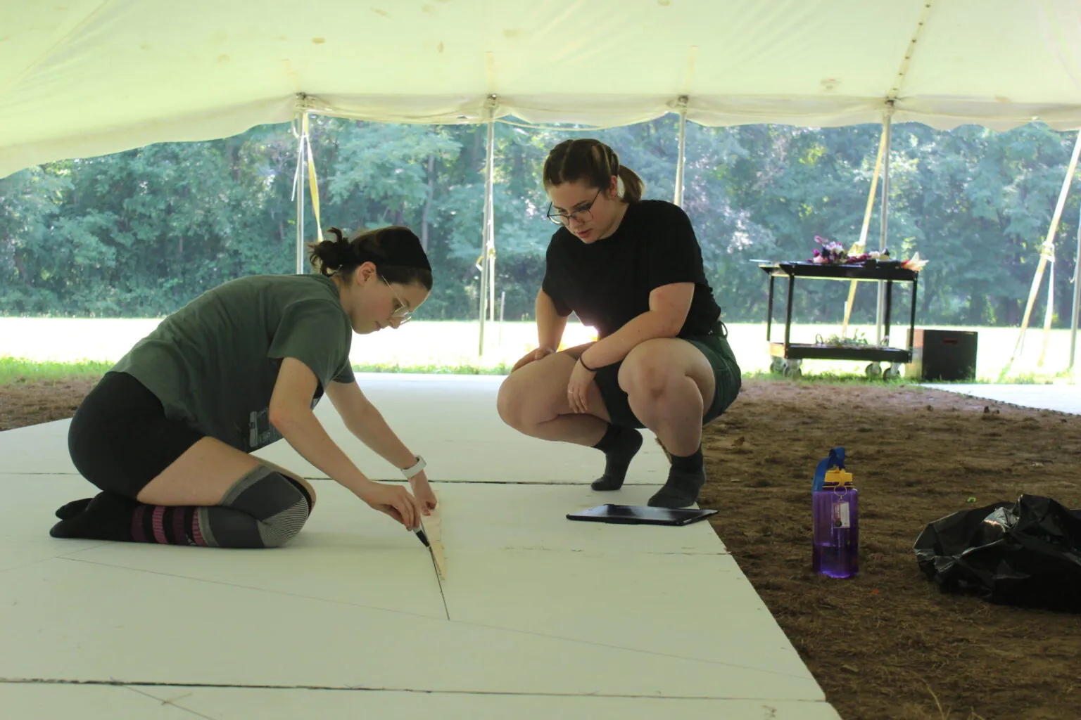 Two teenage girls design A set under a tent